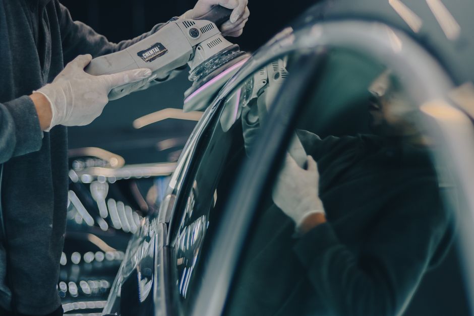 An auto detailing professional meticulously polishing a car exterior
